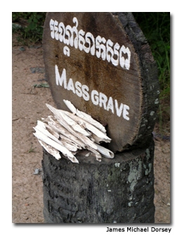 A wooden marker points to a mass grave site.